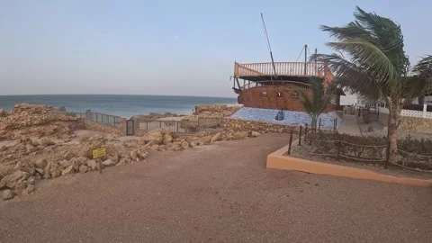 Beachfront setting with a rustic wooden structure appears to be a beachside cafe Stock Footage 295091680