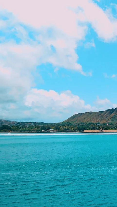 Beachfront skyline with turquoise ocean and mountain backdrop. Vertical video. Video stock 319760855