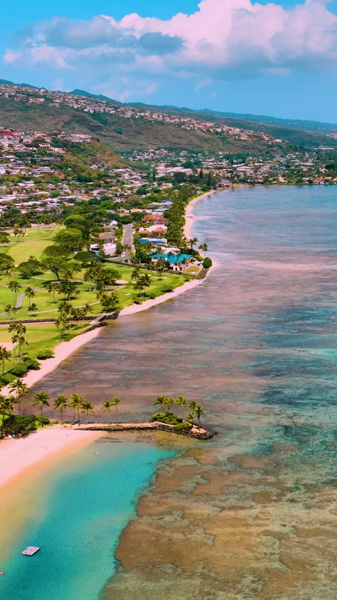 Beachfront with turquoise waters, golf course, and hillside homes. Vertical Stock Footage 319759448
