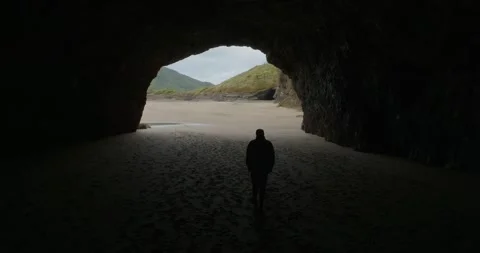 Beachgoer inside a coastal cave. Bethells Beach, Auckland, NZ Stock Footage 295252913