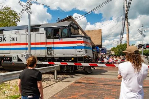 Beachgoers await a train to pass before hitting the sands at Old Orchard Beac Stock Photos