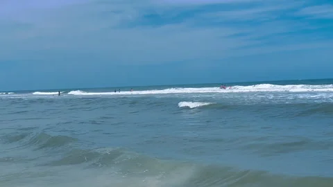 Beachgoers playing in ocean waves at beach on hot sunny day with blue skies Video stock 296788769