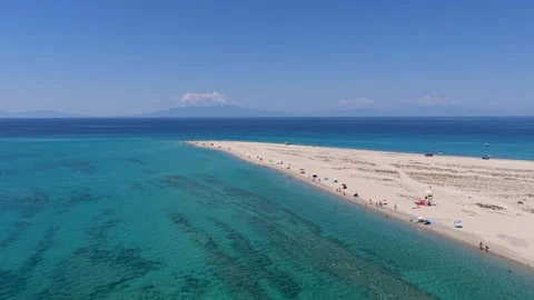 Beachgoers Relaxing Along a Sandy Spit Between Turquoise Waters Stock Footage 340756551