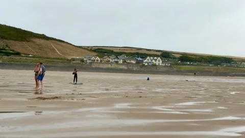 Beachgoers Walking Across Wide Wet Sand at Woolacombe Beach North Devon England Stockbeeldmateriaal 346341446