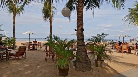 Beachside restaurant with tables and chairs and palm trees Video stock 318630968