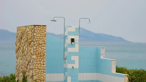A beachside shower structure in Greece with blue tiles, framed by the sea a.. Stock Footage 291083104
