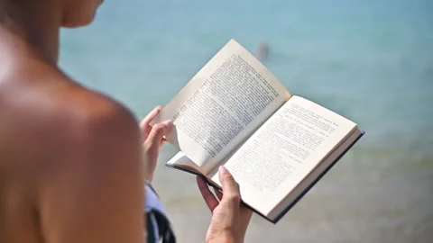 Beachside Tranquility: Close-Up of Woman Reading  Vintage Book Peacefully Stock Footage 250474864