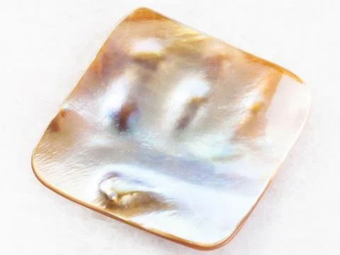 Bead from nacre shell on white marble Stock Photos