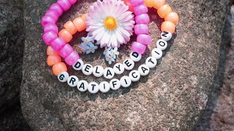 Beaded bracelet made of letter beads spelling: delayed gratification. Stock Footage 340147121
