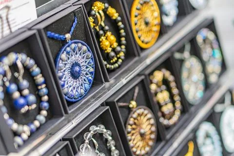 Beaded bracelets of various colors, patterns, and styles on display shelves.. Stock Photos