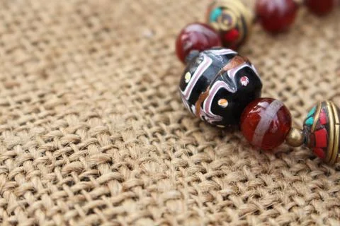 Beaded necklace on sackcloth background Stock Photos