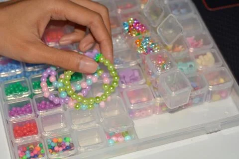 Beading workplace with hands in the process of handicraft. Beautiful diy je.. Stock Photos