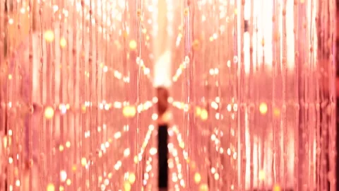 Beads on strings creating a warm, glowing visual texture with out of focus Video stock 330309334