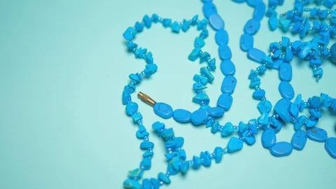 Beads of turquoise on a blue background. copy space Video stock 125255633