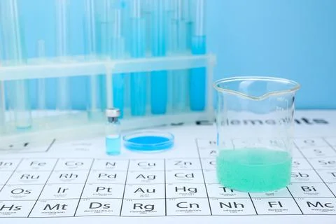 Beaker on periodic table of chemical elements. Space for text Stock Photos