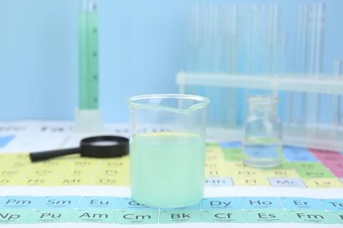 Beaker on periodic table of chemical elements, closeup Stock Photos