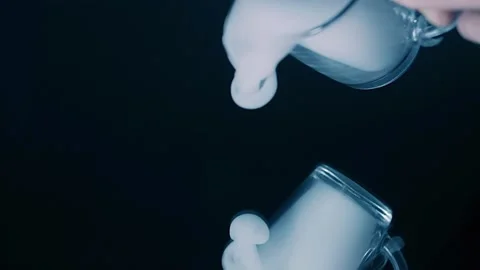 From a beaker, smoke descends onto a mirror surface, forming a layer of smoke Stock Footage 313145626