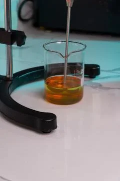 A beaker of yellow liquid is sitting on a table Stock Photos