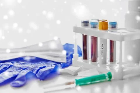 Beakers with virus blood tests, syringe and gloves Stock Photos