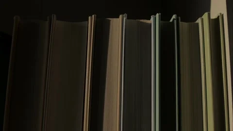 A beam of light glides across the books and disappears into the darkness. Stock Footage 331838437