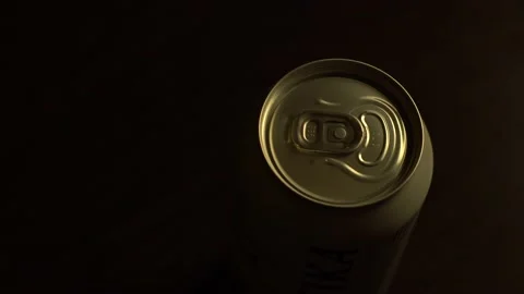 A beam of light slowly illuminates a can of beer in the dark. Stock Footage 132136701