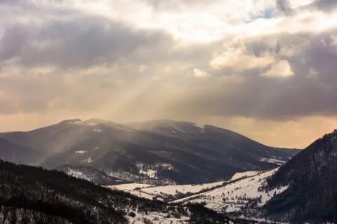 Beam of light through cloudy sky over the mountain Photos