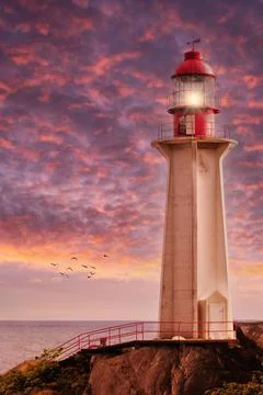 Beaming Lighthouse Under Dramatic Sunset Skies Stock Photos