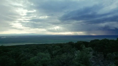 Beaming sunset distant storm in the Rocky Mountains overlooking flat-land drone Stock Footage 276675725