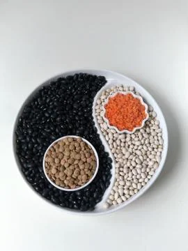 Beans and lentils on the display with a separator in the form of Yin Yang. Fl Stock Photos