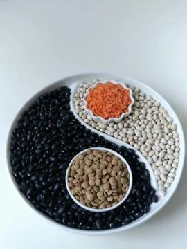 Beans and lentils on the display with a separator in the form of Yin Yang. Fl Stock Photos