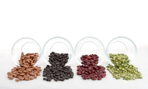 Beans and split peas spilling out of glass jars Stock Photos