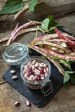 Beans of bean, brown bean (of dried beans) in a glass jar on a rustic table.  Stock Photos