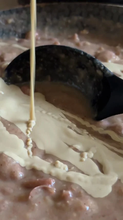 Beans being poured into a pan with simmering stew during home cooking, close up Stock Footage 342574800