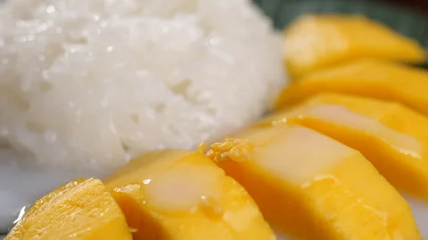 Beans falling into mango sticky rice with coconut milk in slow motion Stock Footage 182740978