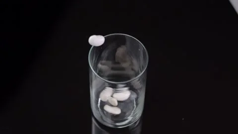 Beans streaming into a glass container in slow motion, against black, portr.. Stock Footage 262731550