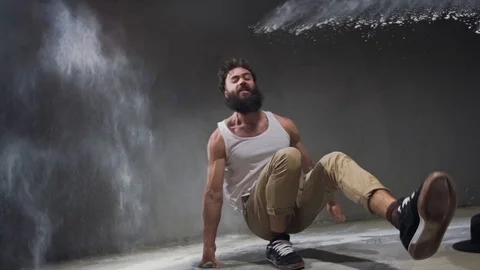 Beard guy a bboying style dancer does difficult tricks on the floor in a studio Stock Footage 119637311