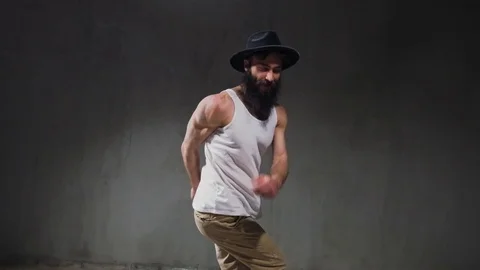 Beard guy a bboying style dancer does difficult tricks on the floor in a studio Stock Footage 119637382