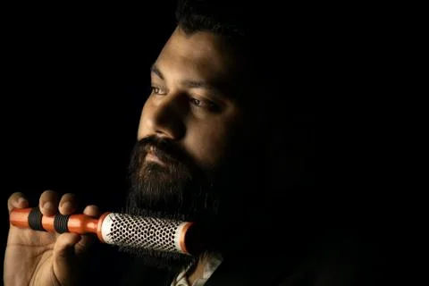 Beard man setting his beard with roller comb Stock Photos