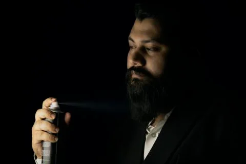 Beard man setting his beard with hair spray Stock Photos