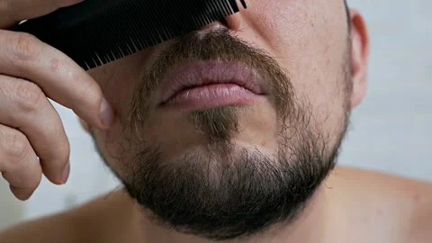 Beard men close up.Hipster man combing beard in front of a mirror Stock Footage 120026330