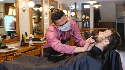 Beard styling. Barber shaping beard of handsome man using a trimmer. Skilled 스톡 동영상 129730109