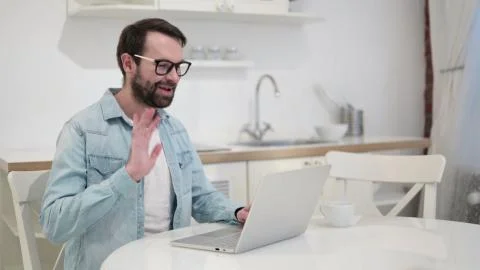 Beard Young Man doing Video Chat on Laptop Stock Photos