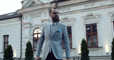 Bearded and elegantly dressed businessman, crosses the street Stock Footage 139965982