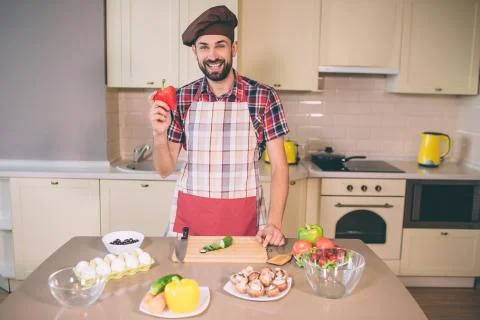 Bearded and handsome guy stands and looks on camera. He smiles. Young man holds Stock Photos