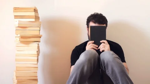 Bearded and handsome man hitting his head with book 스톡 동영상 128299694
