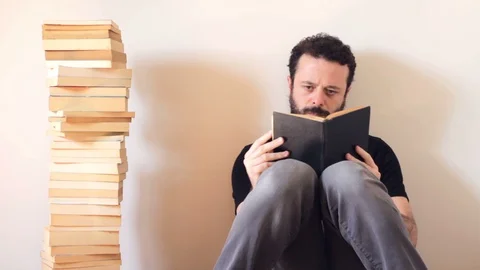 Bearded and handsome man reading book and turning pages Stock Footage 128299569
