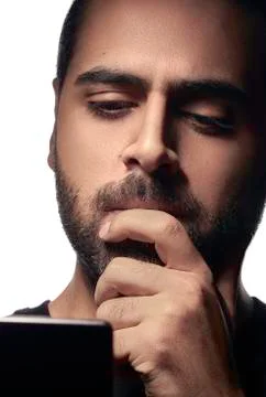 Bearded Arab guy using smartphone and thinking with his hand on mouth isolate Stock Photos