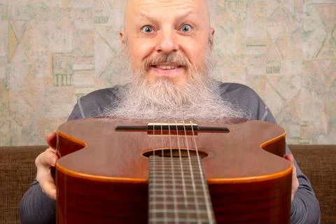 Bearded bald man plays classical guitar Stock Photos