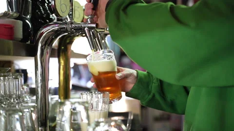 Bearded barman pooring beer from a tap in slow motion Stock Footage 220622971