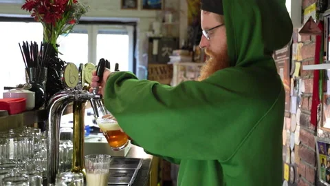 Bearded barman pooring beer from a tap in slow motion Stock Footage 220623053